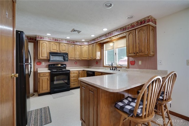 789 W Krepps Rd, Xenia, OH 45385 - kitchen featuring black appliances, a peninsula, light countertops, a breakfast bar area, and recessed lighting