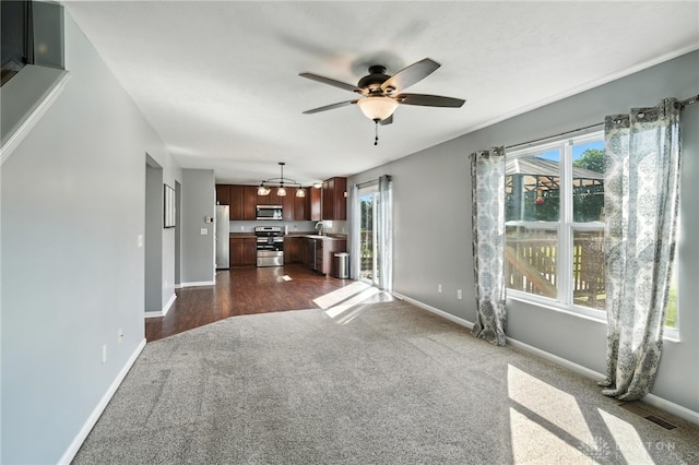 171 Shanda Dr, Monroe, OH 45050 - unfurnished living room featuring dark colored carpet, a ceiling fan, and plenty of natural light