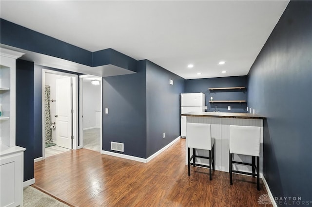 171 Shanda Dr, Monroe, OH 45050 - kitchen with open shelves, freestanding refrigerator, wood finished floors, a breakfast bar, and recessed lighting