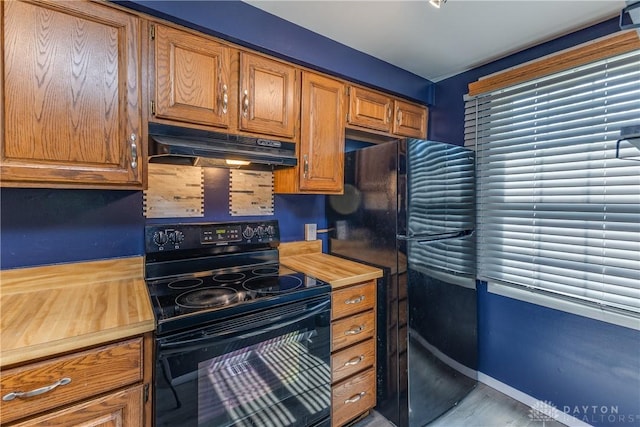 6235 Pheasant Hill Rd, Dayton, OH 45424 - kitchen with black appliances, under cabinet range hood, wooden counters, and brown cabinets