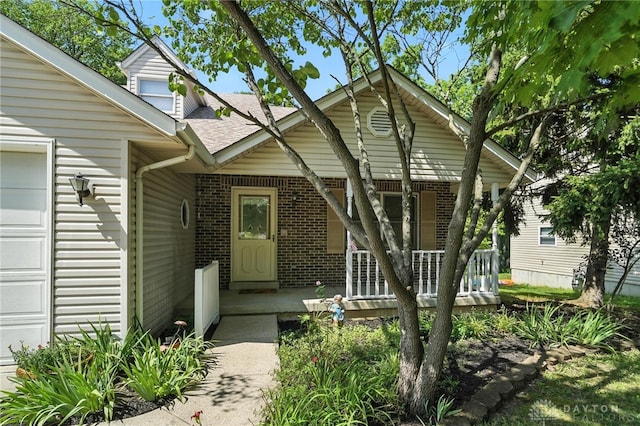 500 Smalley Blvd, Hamilton, OH 45013 - view of front of house featuring a porch, roof with shingles, brick siding, and a garage