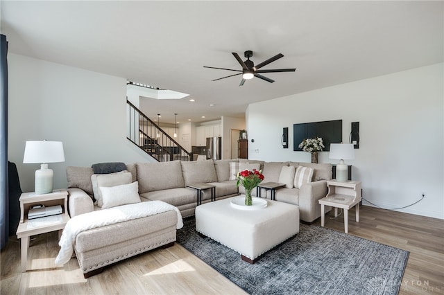 598 Twilight Ln, Dayton, OH 45440 - living room with light wood-style flooring, ceiling fan, and stairs