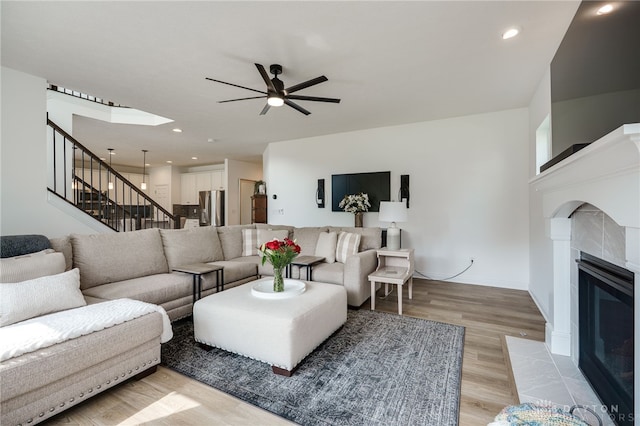 598 Twilight Ln, Dayton, OH 45440 - living room featuring a ceiling fan, light wood-style floors, stairs, a tile fireplace, and recessed lighting