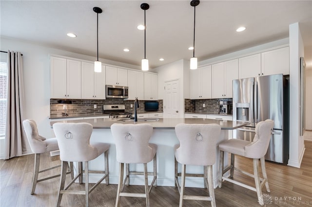 598 Twilight Ln, Dayton, OH 45440 - kitchen featuring stainless steel appliances, decorative backsplash, an island with sink, white cabinetry, and recessed lighting