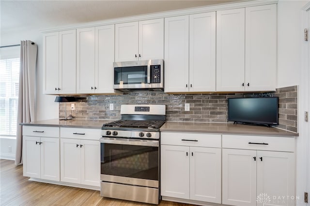 598 Twilight Ln, Dayton, OH 45440 - kitchen with stainless steel appliances, white cabinets, backsplash, and light wood-type flooring