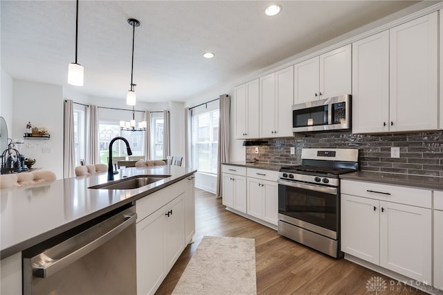 598 Twilight Ln, Dayton, OH 45440 - kitchen featuring stainless steel appliances, tasteful backsplash, wood finished floors, recessed lighting, and a chandelier