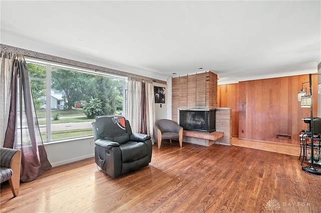 6101 Capri Dr, Cincinnati, OH 45224 - sitting room featuring a fireplace, wood finished floors, and wooden walls