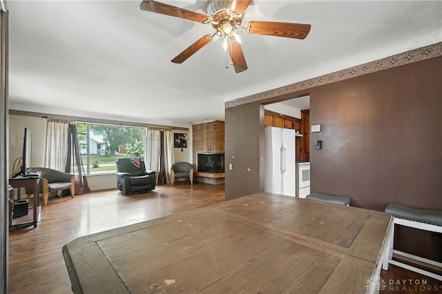 6101 Capri Dr, Cincinnati, OH 45224 - dining room with wood finished floors, a ceiling fan, and a fireplace