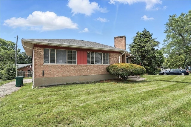 6101 Capri Dr, Cincinnati, OH 45224 - view of side of home featuring a chimney, brick siding, and a lawn