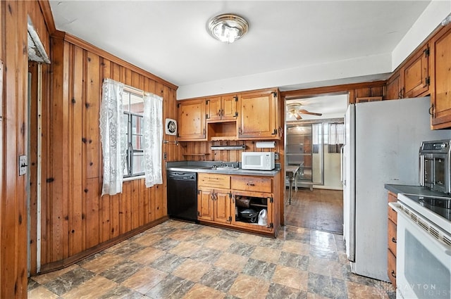 6101 Capri Dr, Cincinnati, OH 45224 - kitchen featuring white appliances, stone finish flooring, wood walls, brown cabinetry, and a ceiling fan