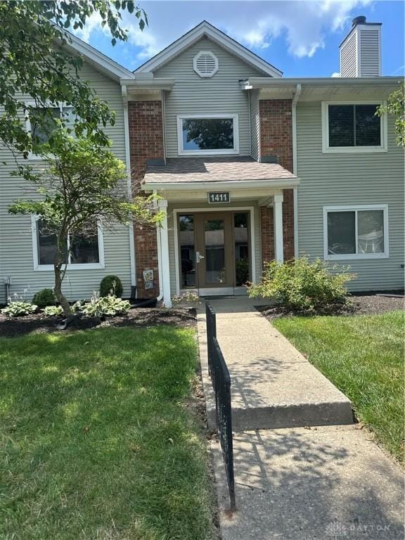 1411 Lake Pointe Way Unit 8, Washington Twp, OH 45459 - view of front of house featuring a front lawn, a chimney, and brick siding