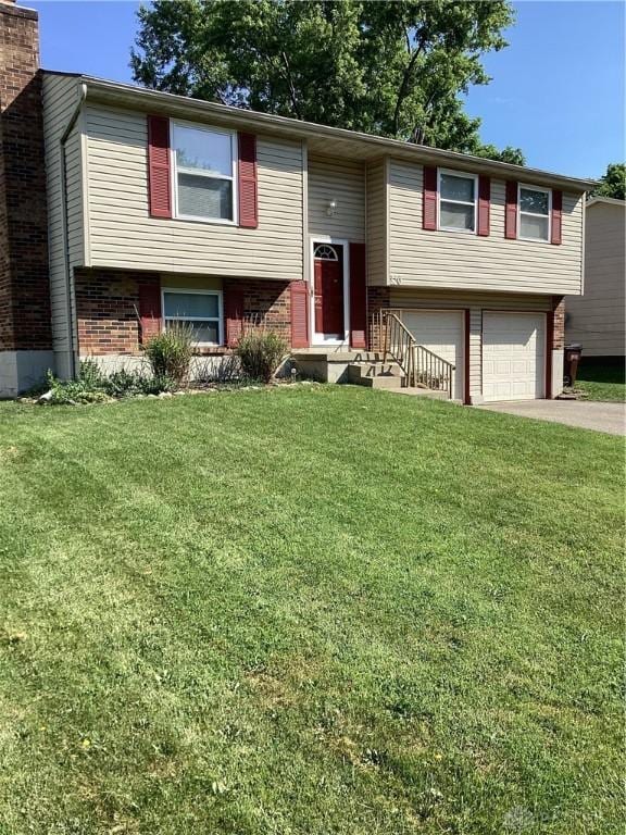 150 Lexington Farm Rd, Englewood, OH 45322 - split foyer home featuring concrete driveway, an attached garage, brick siding, a front yard, and a chimney