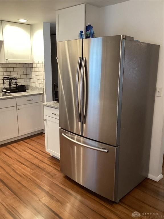 150 Lexington Farm Rd, Englewood, OH 45322 - kitchen with freestanding refrigerator, white cabinetry, decorative backsplash, and light wood finished floors