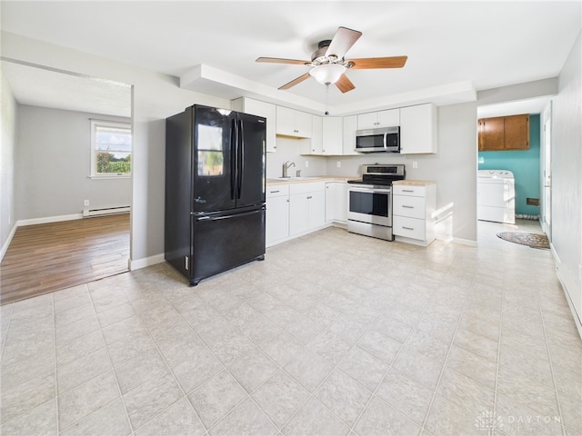 3862 State Route 49, Arcanum, OH 45304 - kitchen with stainless steel appliances, washer / dryer, light countertops, a baseboard radiator, and white cabinets