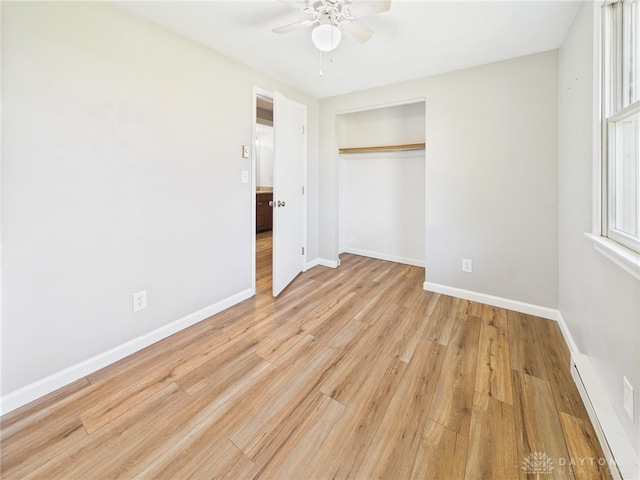3862 State Route 49, Arcanum, OH 45304 - unfurnished bedroom featuring a baseboard radiator, a closet, light wood-style flooring, and ceiling fan