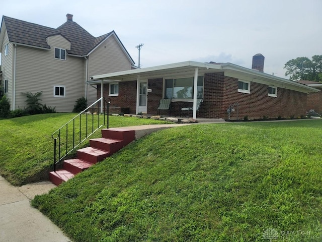 612 E Market St, Xenia, OH 45385 - view of front of property with a chimney, brick siding, and a front yard