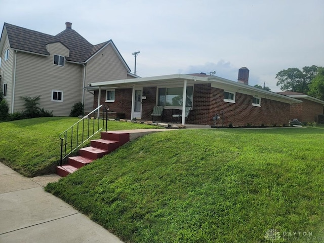 612 E Market St, Xenia, OH 45385 - view of front of property featuring a front lawn, brick siding, and a chimney