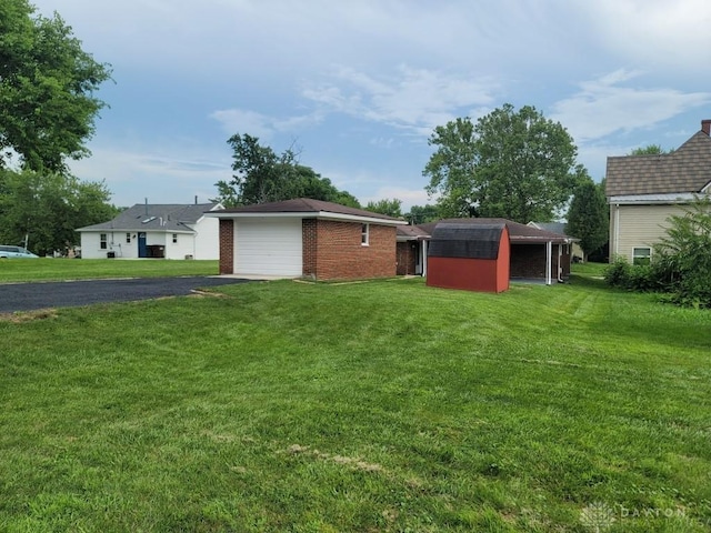612 E Market St, Xenia, OH 45385 - back of house featuring a garage, driveway, a yard, and a storage shed