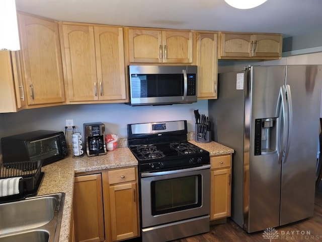 612 E Market St, Xenia, OH 45385 - kitchen with appliances with stainless steel finishes, light brown cabinetry, dark wood finished floors, and light stone countertops