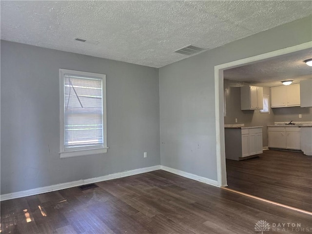 1958 Wesleyan Rd, Dayton, OH 45406 - unfurnished dining area with a textured ceiling and dark wood finished floors