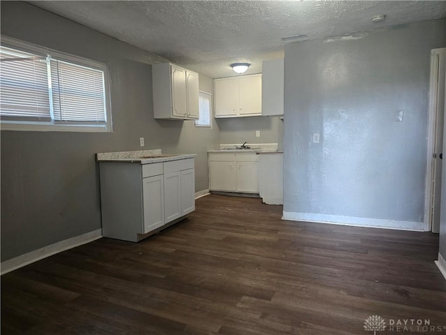 1958 Wesleyan Rd, Dayton, OH 45406 - kitchen featuring a textured ceiling, dark wood-style floors, white cabinetry, and light countertops
