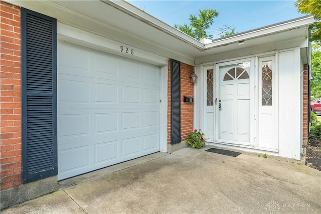 928 E Stroop Rd, Kettering, OH 45429 - view of exterior entry with brick siding, concrete driveway, and a garage