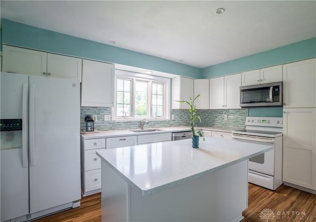 928 E Stroop Rd, Kettering, OH 45429 - kitchen with appliances with stainless steel finishes, light countertops, backsplash, white cabinets, and a center island