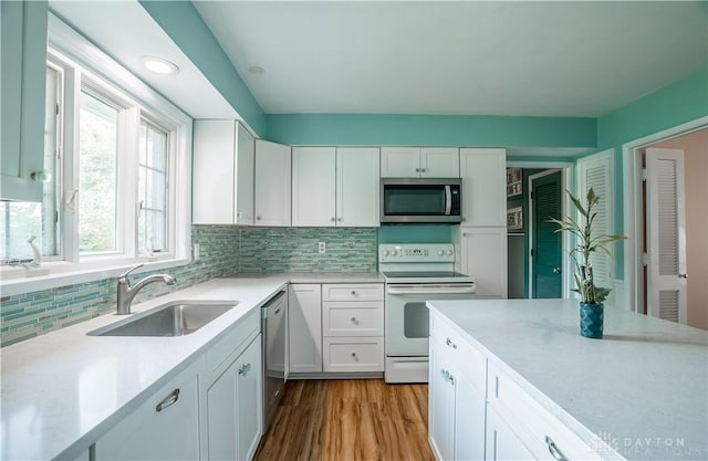 928 E Stroop Rd, Kettering, OH 45429 - kitchen with stainless steel appliances, light countertops, white cabinetry, backsplash, and wood finished floors