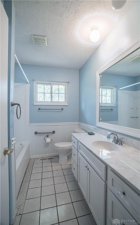 928 E Stroop Rd, Kettering, OH 45429 - bathroom featuring wainscoting, vanity, plenty of natural light, a textured ceiling, and tub / shower combination