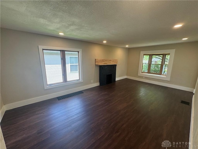 2627 Wayland Ave, Dayton, OH 45420 - unfurnished living room featuring dark wood-style flooring, recessed lighting, a fireplace, and a textured ceiling