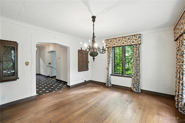 715 E Schantz Ave, Oakwood, OH 45419 - unfurnished dining area featuring a chandelier, arched walkways, wood-type flooring, and crown molding
