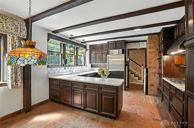 715 E Schantz Ave, Oakwood, OH 45419 - kitchen featuring under cabinet range hood, light countertops, brick floors, dark brown cabinets, and stainless steel appliances