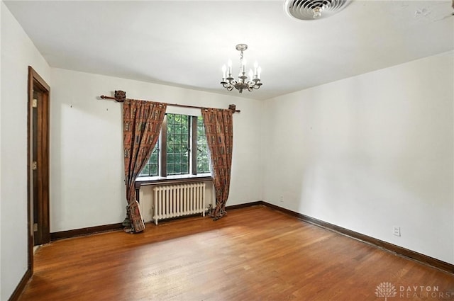 715 E Schantz Ave, Oakwood, OH 45419 - spare room with radiator heating unit, a chandelier, and wood finished floors