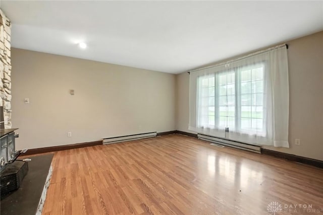 2042 Hilltop Rd, Xenia, OH 45385 - unfurnished living room featuring a baseboard heating unit and light wood-type flooring