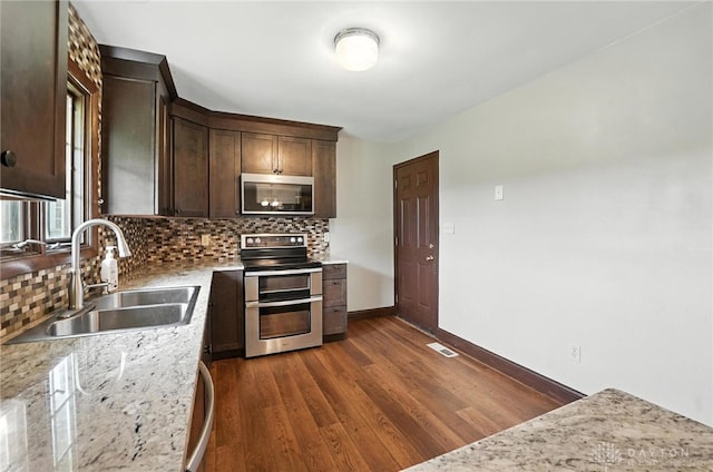 2042 Hilltop Rd, Xenia, OH 45385 - kitchen with stainless steel appliances, decorative backsplash, dark wood finished floors, and dark brown cabinetry