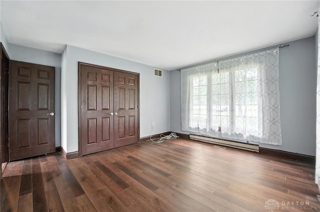 2042 Hilltop Rd, Xenia, OH 45385 - unfurnished bedroom featuring a baseboard radiator, a closet, and dark wood-style flooring