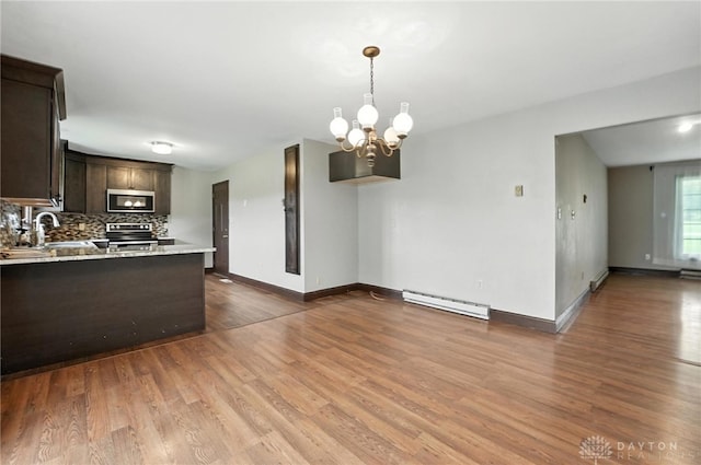 2042 Hilltop Rd, Xenia, OH 45385 - kitchen featuring appliances with stainless steel finishes, a baseboard radiator, dark brown cabinets, light countertops, and a chandelier
