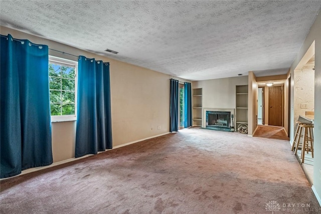 8869 Washington Colony Dr, Dayton, OH 45458 - unfurnished living room featuring a textured ceiling, a fireplace, and carpet floors