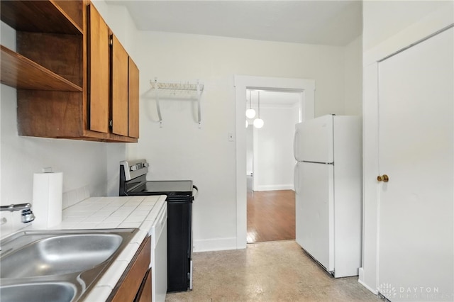 38-40 Greenwood Ave, Dayton, OH 45410 - kitchen with freestanding refrigerator, stainless steel electric stove, tile counters, brown cabinetry, and open shelves