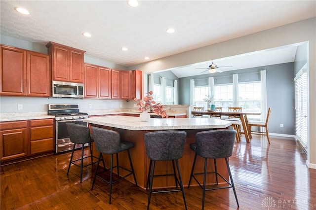 2937 E Ambrosia Ln, Xenia, OH 45385 - kitchen with appliances with stainless steel finishes, light countertops, a breakfast bar, a kitchen island, and recessed lighting