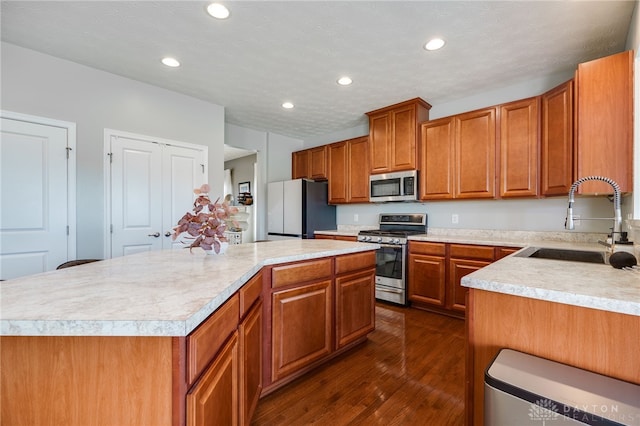 2937 E Ambrosia Ln, Xenia, OH 45385 - kitchen with appliances with stainless steel finishes, a center island, light countertops, dark wood-style floors, and recessed lighting
