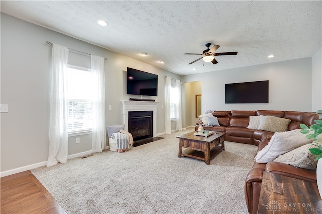 2937 E Ambrosia Ln, Xenia, OH 45385 - living area featuring a fireplace with flush hearth, a ceiling fan, a textured ceiling, recessed lighting, and carpet floors