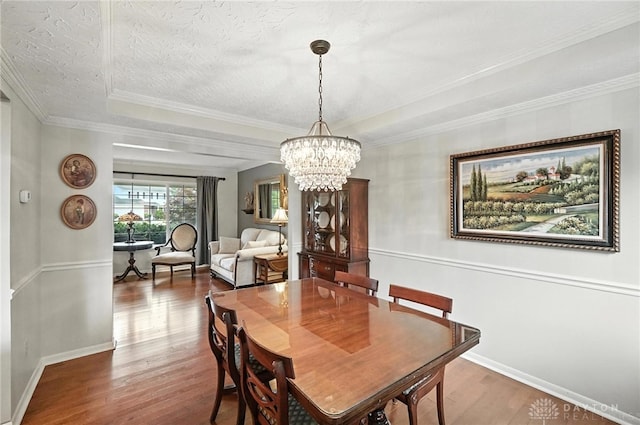 7793 Birchwood Ct, Mason, OH 45040 - dining space featuring wood finished floors, a chandelier, crown molding, and a textured ceiling