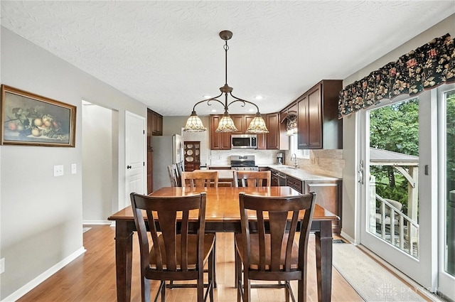 7793 Birchwood Ct, Mason, OH 45040 - dining area featuring light wood-style flooring, a chandelier, recessed lighting, and a textured ceiling