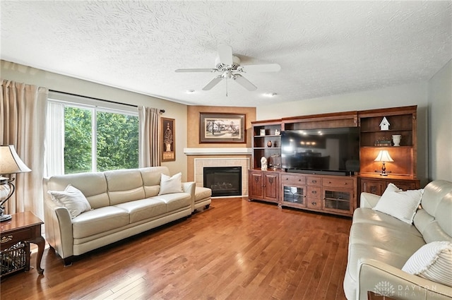 7793 Birchwood Ct, Mason, OH 45040 - living room featuring wood finished floors, a ceiling fan, a textured ceiling, and a fireplace