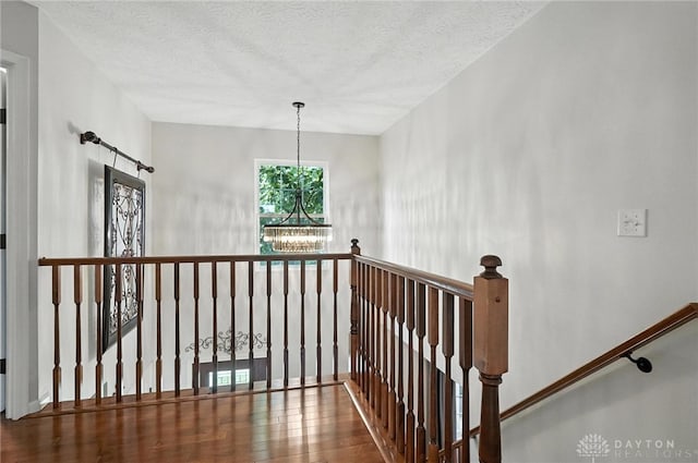 7793 Birchwood Ct, Mason, OH 45040 - stairs featuring wood finished floors, a textured ceiling, and a chandelier