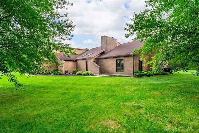 4230 Wagner Rd, Dayton, OH 45440 - mid-century modern home featuring a front lawn, a chimney, and brick siding