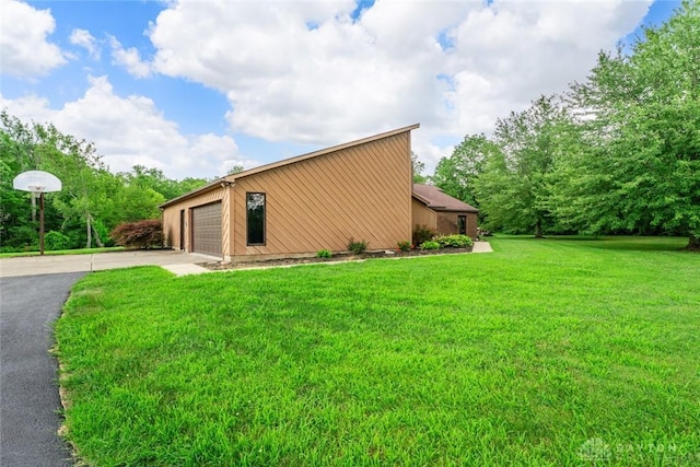 4230 Wagner Rd, Dayton, OH 45440 - view of side of home featuring a garage, a lawn, and driveway