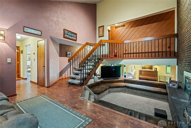 4230 Wagner Rd, Dayton, OH 45440 - living area with wood finished floors, a high ceiling, a fireplace, and stairway