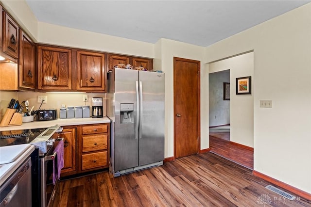 4230 Wagner Rd, Dayton, OH 45440 - kitchen with stainless steel appliances, dark wood finished floors, light countertops, and brown cabinets